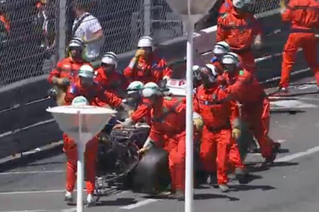 Стюарды эвакуируют то, что осталось от машины Мальдонадо.