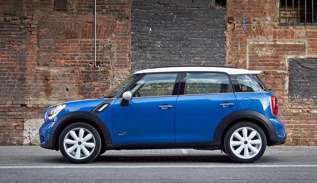Синий кроссовер MINI с белой крышей и белыми дисками - стильная штучка. И компактная -- припарковаться на нем не сложнее, чем на любом хэтчбеке В-класса. Точнее, даже проще: у него короткие свесы и дорожный просвет чуть больше, чем у маленьких хэтчей.