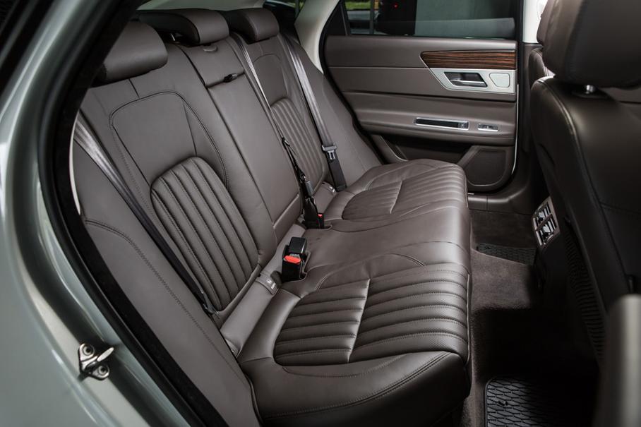 Сзади в XF особо не разгуляешься: ни тебе собственной климатической зоны, ни прочих роскошеств. Еще и подушка дивана сильно завалена назад, поэтому на втором ряду сидишь, задрав коленки к потолку. Не то чтобы здесь было тесно или неудобно, но Jaguar отчетливо дает понять, что лучшее место в нем — водительское. И это правильно.