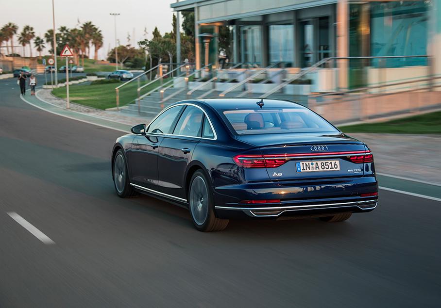 Сзади узнать новую Audi A8 куда проще, чем спереди. Тут и характерный светодиодный мост, соединивший задние фары и протянувшийся через всю крышку багажника, и органические светодиоды с регулируемой яркостью. Патрубки выпускной системы, кстати, фальшивые – сам выпуск выведен вниз, под бампер.