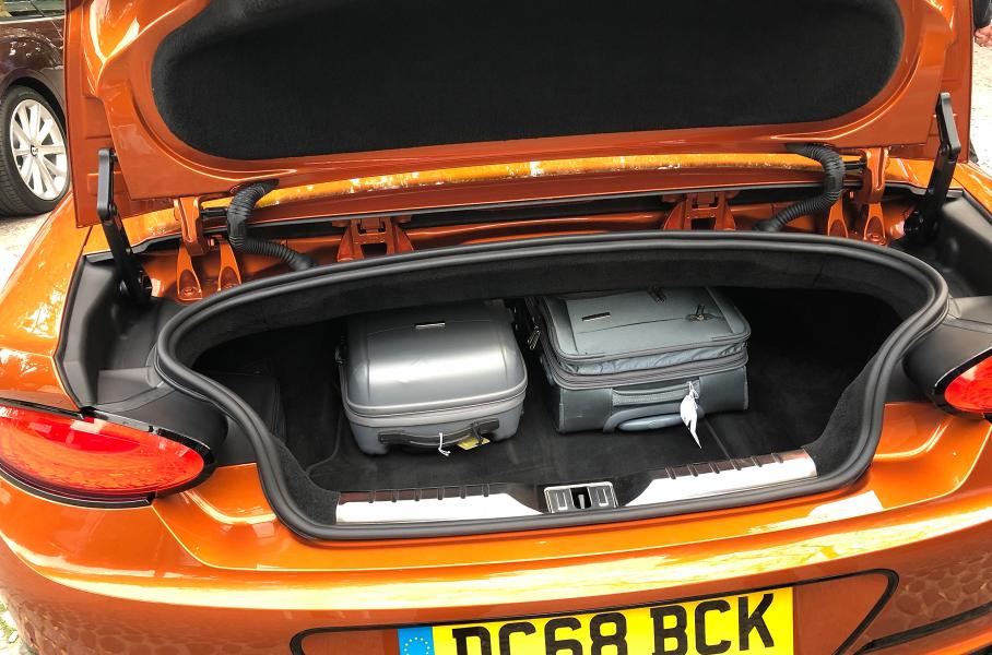 Объем багажника и доступ к вещам не зависят от положения крыши. Отсек большой, но высота его невелика, а по бокам пространство отъедают арки — колеса Continental GT стали исполинскими: размерность задних шин — 315/30 ZR22. Тем не менее в багажник легко влезают два «кабинных» чемодана и две большие сумки. Компоновщики утверждают, что войдут и два среднеразмерных 28-дюймовых чемодана.