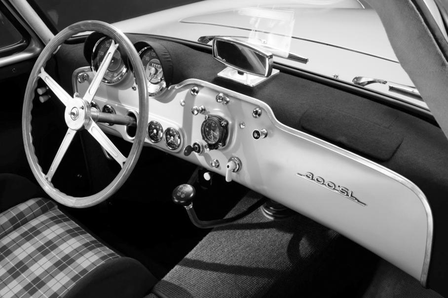 Истинное украшение минималистского, но стильного  интерьера 300 SL кресла в клетку и хронометры фирмы Junghans прямо по центру приборной панели. Точно такие же ставили на бомбардировщики Junkers Ju87 в годы Второй мировой.